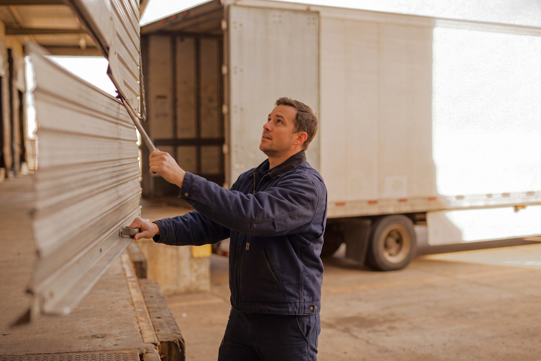 A driver closing the trailer at the loading dock