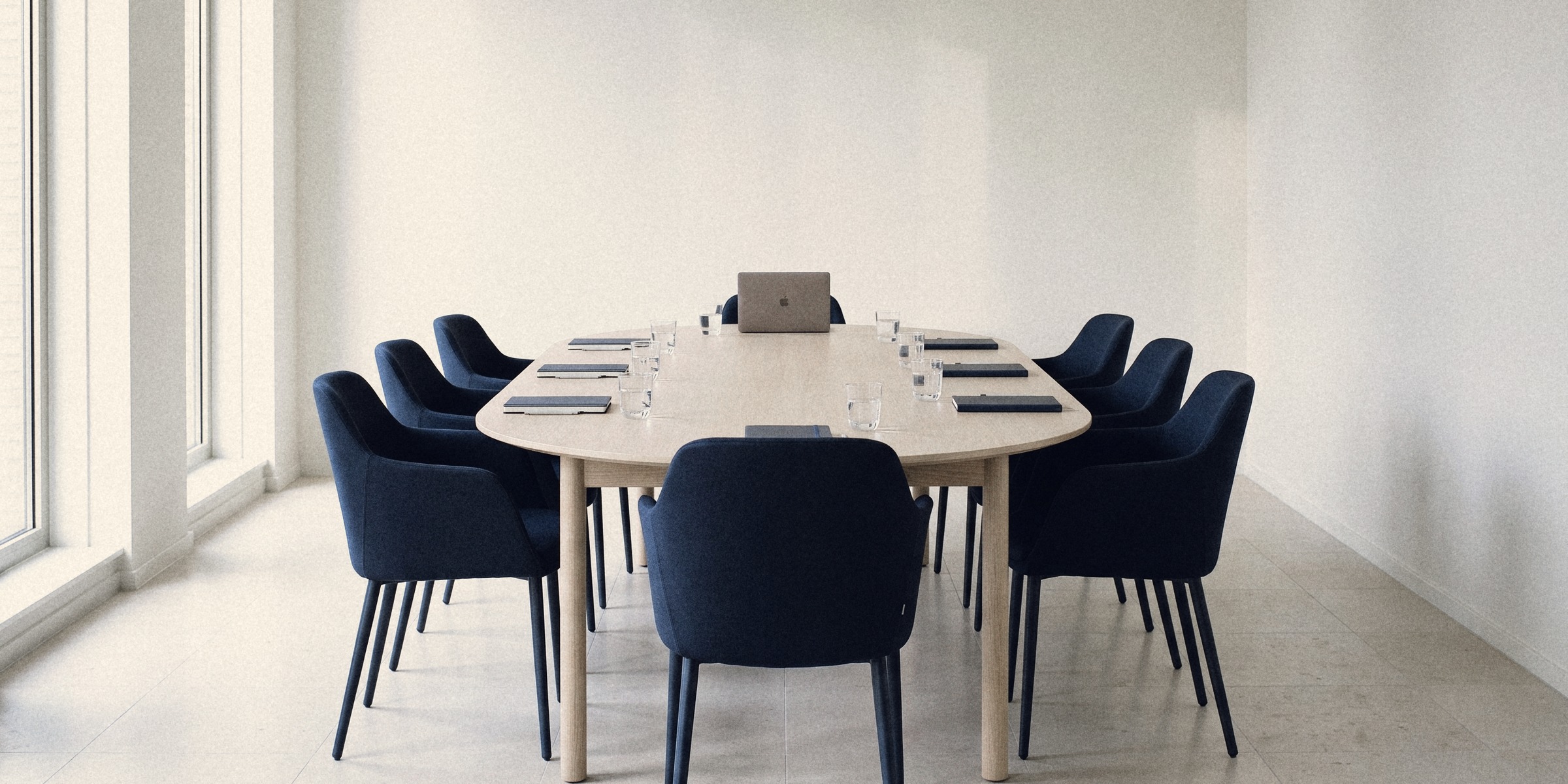 An empty meeting room set for a works council meeting, water and notebooks at every place